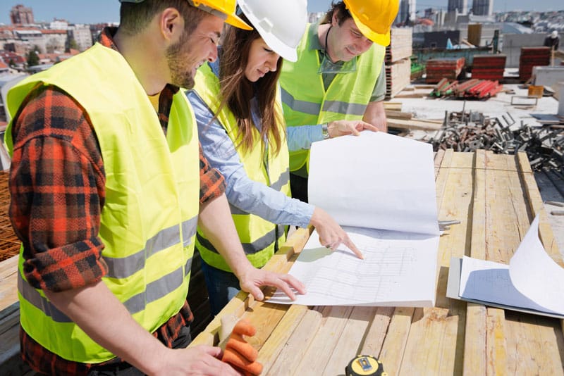 Construction workers looking over blueprints