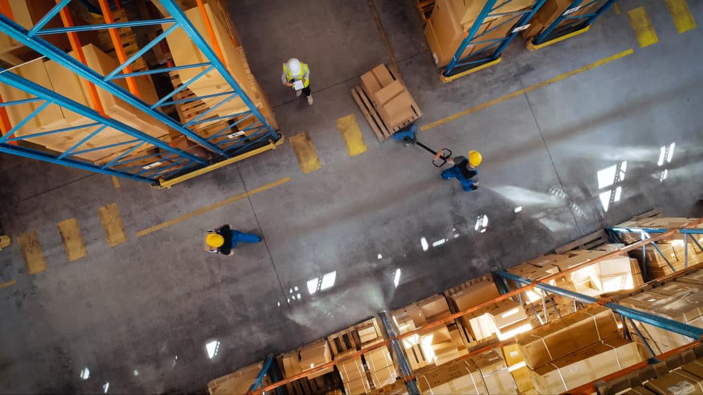Distribution workers moving pallets in a warehouse